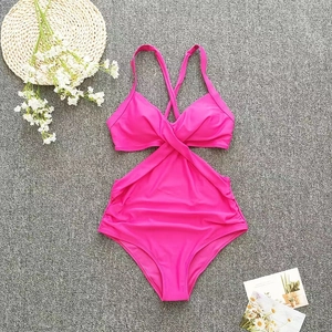 Detailed flat lay of hot pink one-piece swimsuit with waist cutouts and cross back design