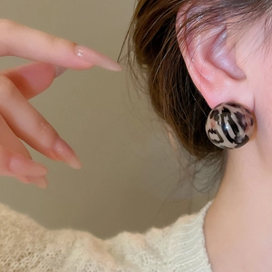 Close-up of vintage round resin earrings with a stylish brown leopard print pattern