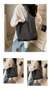 Detail of grey polka dot bucket bag with black base and bow closure on a model