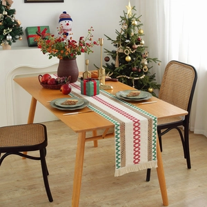 Rustic Christmas table runner with geometric red and green weaving and fringe tassels