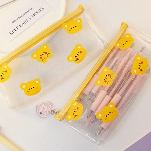 Detail of transparent glitter pencil case with yellow bear pattern and heart zipper pull