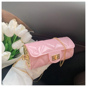Detailed view of pink cylinder jelly bag with quilted texture and gold chain strap