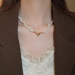 Baroque freshwater pearl necklace featuring a 18K gold heart pendant on a female model