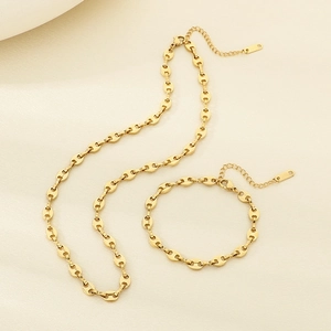 Détail d'un ensemble de collier et bracelet à maillons en acier inoxydable doré 18 carats