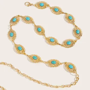 Detailed macro of golden hollow metal belt with oval turquoise insets and lobster clasp