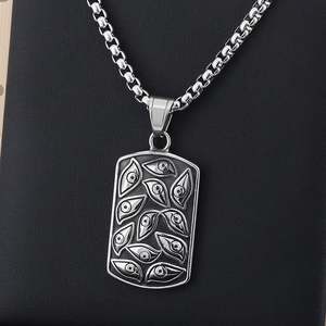 Close-up of silver Eye of Providence pendant on black leather with gothic details