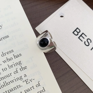 Detailed view of a wide 925 silver ring featuring a black agate stone on book pages