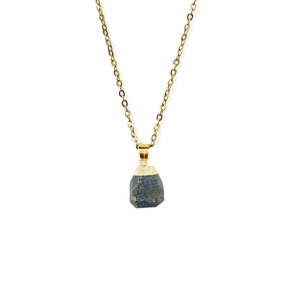 Macro detail of natural raw stone pendant on a delicate gold chain necklace