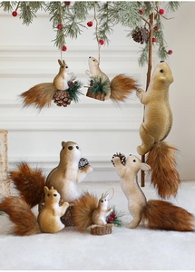 Close-up of decorative Christmas foam squirrels with pine cones and faux fur details