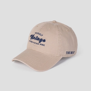 Detail of navy blue letter embroidery on khaki cotton baseball cap with ventilation eyelets