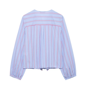 Detail of blue and white striped shirt featuring pleated cuffs and button closure