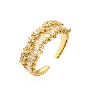 Macro view of adjustable gold-plated ring with inlaid baguette and round cubic zirconia