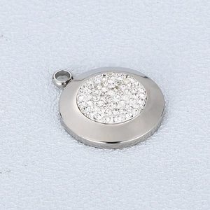 Macro shot of silver stainless steel round pendant with dense sparkling diamond inlay