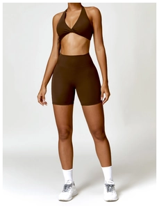 Close-up of deep brown yoga set featuring a halter twist sports bra and high-waist shorts