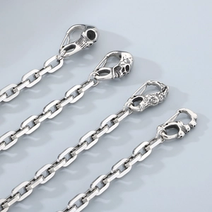 Detail of four silver titanium steel trousers chains with skull clasps and square links