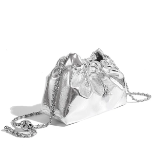 Detail of silver pleated cloud bag with metallic finish, chain strap and pearl charm