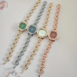Detail of four quartz watches with metal chain bands and colorful rhinestone dials