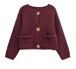 Close-up of wine red chunky knit cardigan with gold textured buttons and front pockets