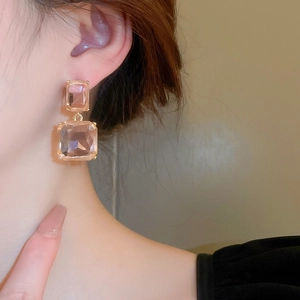 Close-up of double square champagne crystal earrings with gold metal plating on model