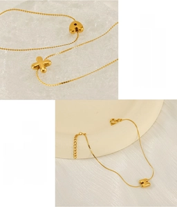 Detail of gold stainless steel necklace with initial pendants on ceramic plate