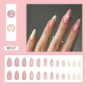 Detail view of pink and white French press-on nails with heart patterns and 24 pieces