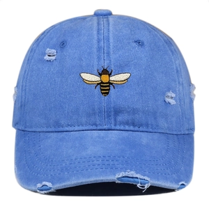 Close-up of vintage denim blue baseball cap with bee embroidery and distressed details