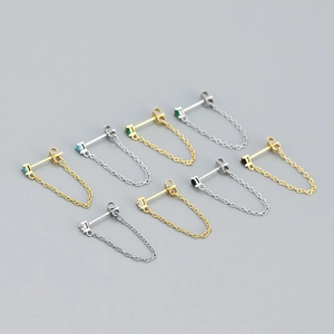 Detailed view of silver and gold chain earrings with colorful cubic zirconia stones