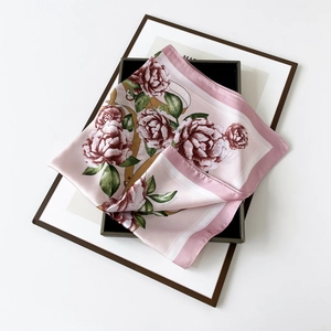 Detail view of pink satin silk square scarf with rose pattern in a gift box