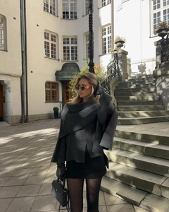 Detail of dark grey wool knit shawl jacket paired with elegant black leather gloves
