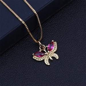 Close-up of golden butterfly necklace pendant with red marquise-cut crystals and fine details
