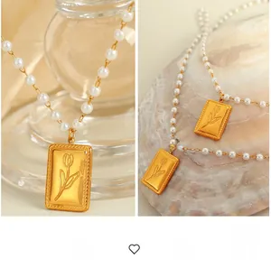 Dettaglio del ciondolo a tulipano dorato in rilievo su una collana di perle bianche