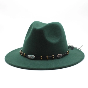 Detail of dark green fedora hat featuring a bohemian woven band with turquoise beads