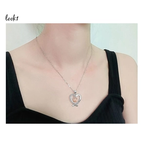 Detail of silver heart pendant with rose gold crown and I love you Mom engraving