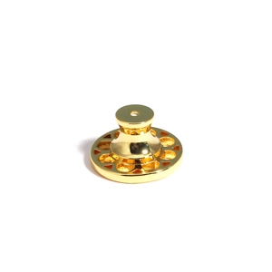 Macro shot of golden polished earring lifter with decorative disk base and butterfly clasp