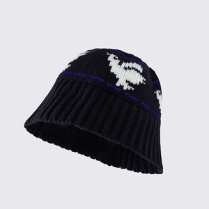 Close-up of crochet knit bucket hat featuring white animal jacquard and blue wave patterns