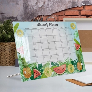 Detail of transparent acrylic monthly planner board with tropical fruit motifs and metal stand