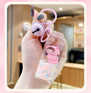 Detail of pink liquid quicksand keychain featuring a cute cartoon bear doll and bell