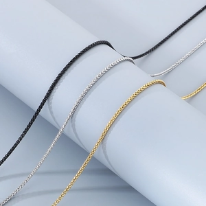 Detailed close-up of woven stainless steel chains in black, silver, and gold finishes