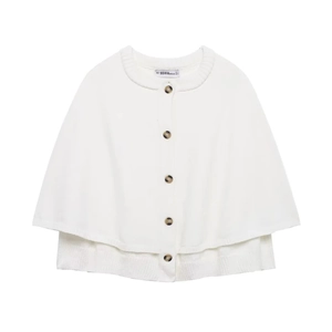 Close-up of white knit cape cardigan with round neck and brown tortoiseshell buttons