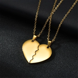 Macro detail of golden heart pendant necklace set on a luxury black leather background