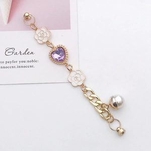 Detail of DIY phone case charm with white enamel camellia, purple heart crystal and pearl