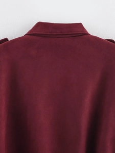 Detail of the suede fabric texture and back collar on a burgundy aviator jacket