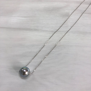 Detail of a lustrous grey round pearl pendant on a thin silver s925 necklace chain