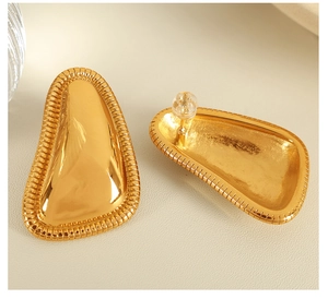 Detailed macro shot of 18K gold geometric earrings with elegant braided texture