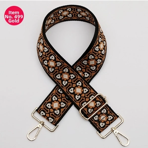 Close-up of bohemian geometric patterns on wide woven strap with gold metal buckles