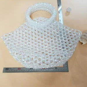 Detailed size measurement of a white iridescent beaded fan-shaped handbag with ruler