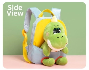 Detail van een blauwe dinosaurus schooltas met groene knuffel en gele banden
