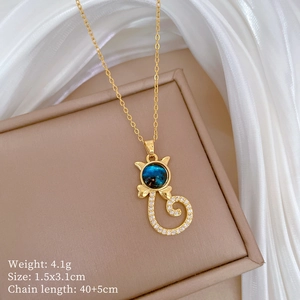 Golden cat necklace with blue starry stone and crystals on beige display mat