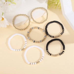 Detail of 7-piece bohemian bracelets with gold beads and black white Heishi clay disks