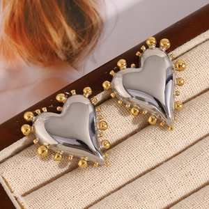 Macro shot of gold-beaded edges on silver heart studs displayed in a luxury jewelry box